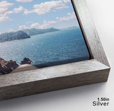 The image is a framed photograph of a scenic ocean view, with a rocky coastline and a clear blue sky in the background.