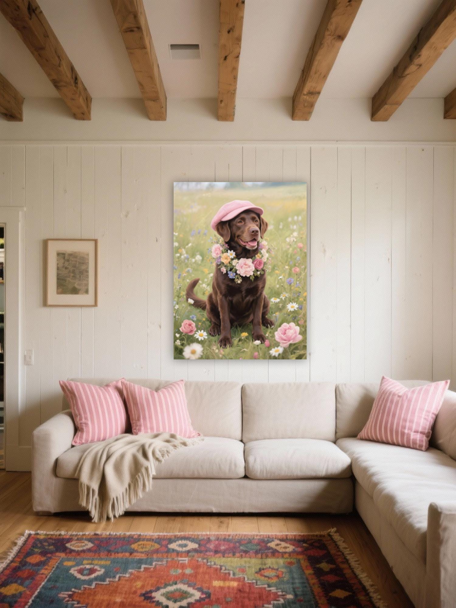 a cozy living room with a large, framed photograph of a dog sitting in a field of flowers hanging on the wall. The dog is wearing a pink hat and has a bouquet of flowers around its neck. The room has a beige sofa with pink and white striped pillows, and a colorful rug on the floor.